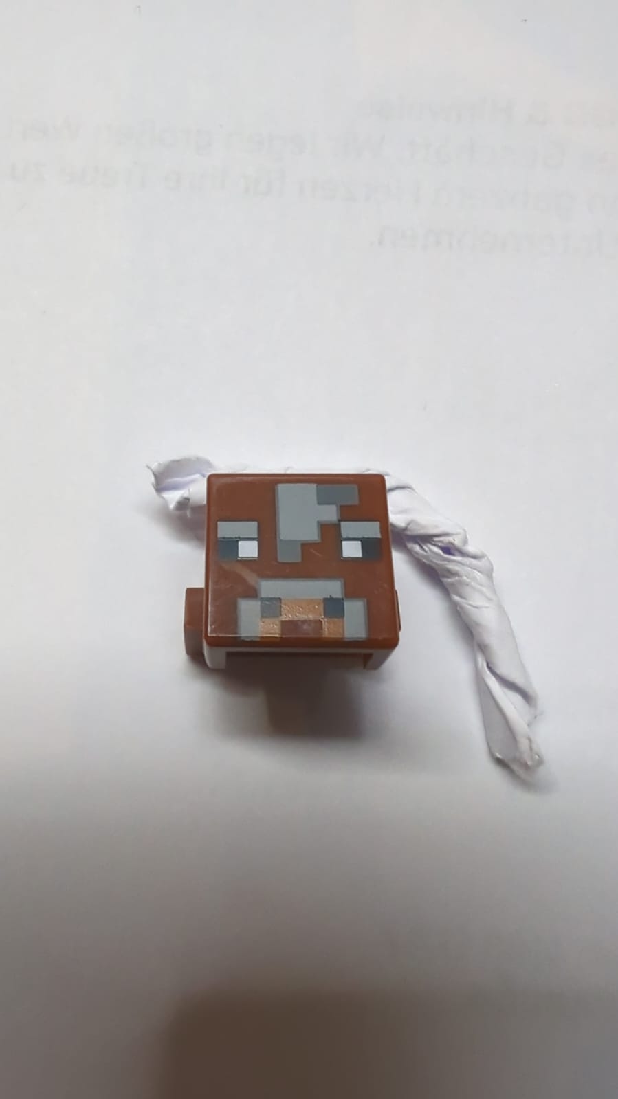 Kreaturenkopf pixelartig mit hellblau-grauem und dunkelblau-grauem Gesichtsmuster (Minecraft Kuh) neubraun