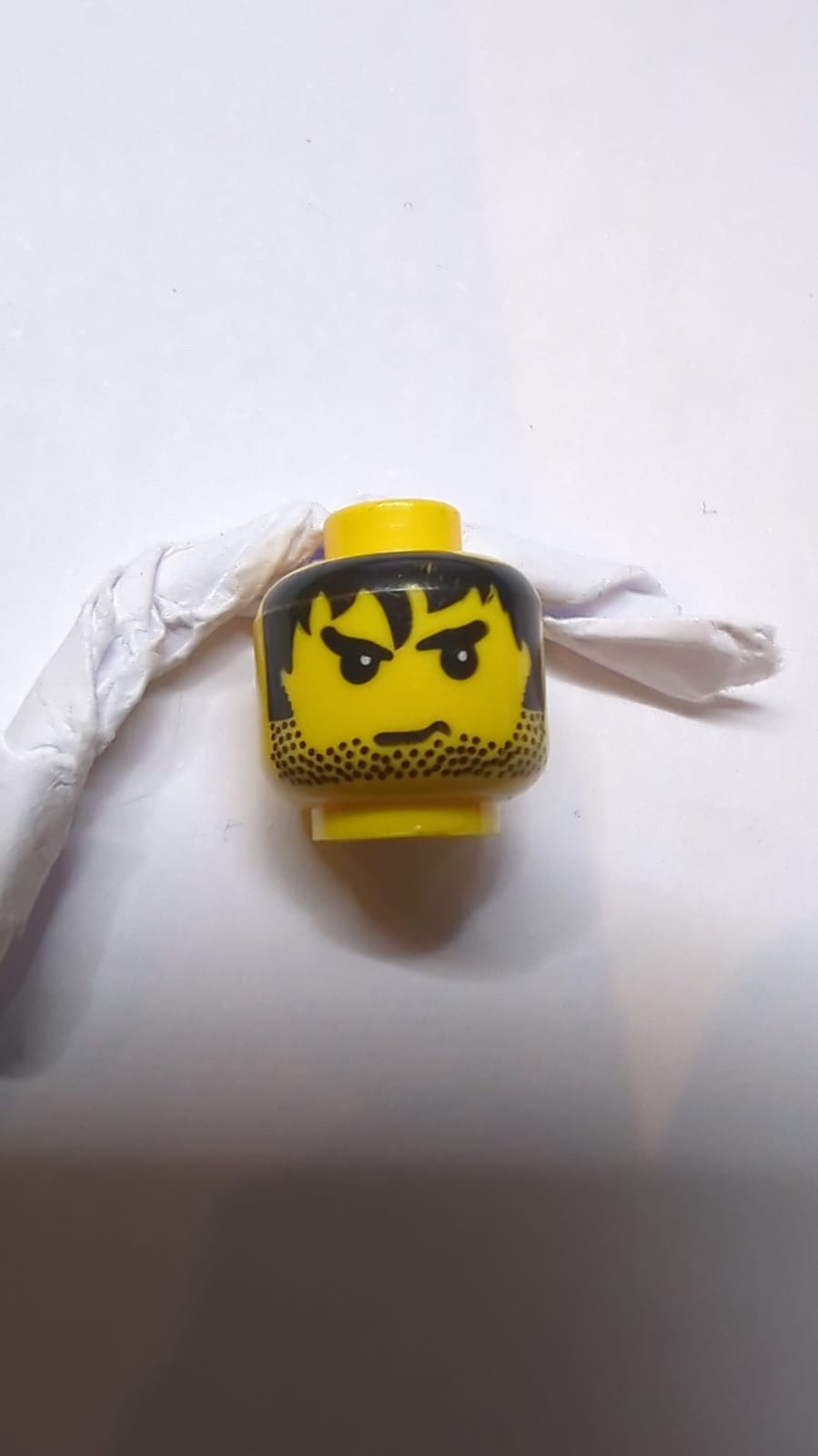 Kopf männlich mit Stoppelbart, schwarzes zerzaustes Haar und wütendes Augenbrauenmuster gelb