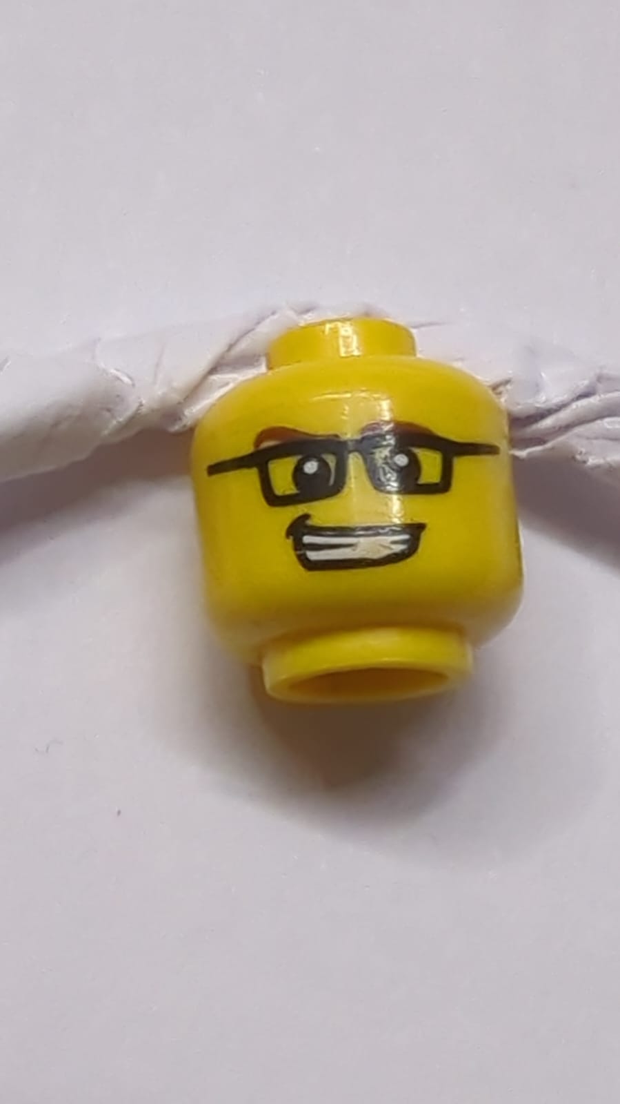 Kopf rötlich-braune Augenbrauen, schwarze rechteckige Brille, schiefer offener Mund mit Zahnaufdruck gelb