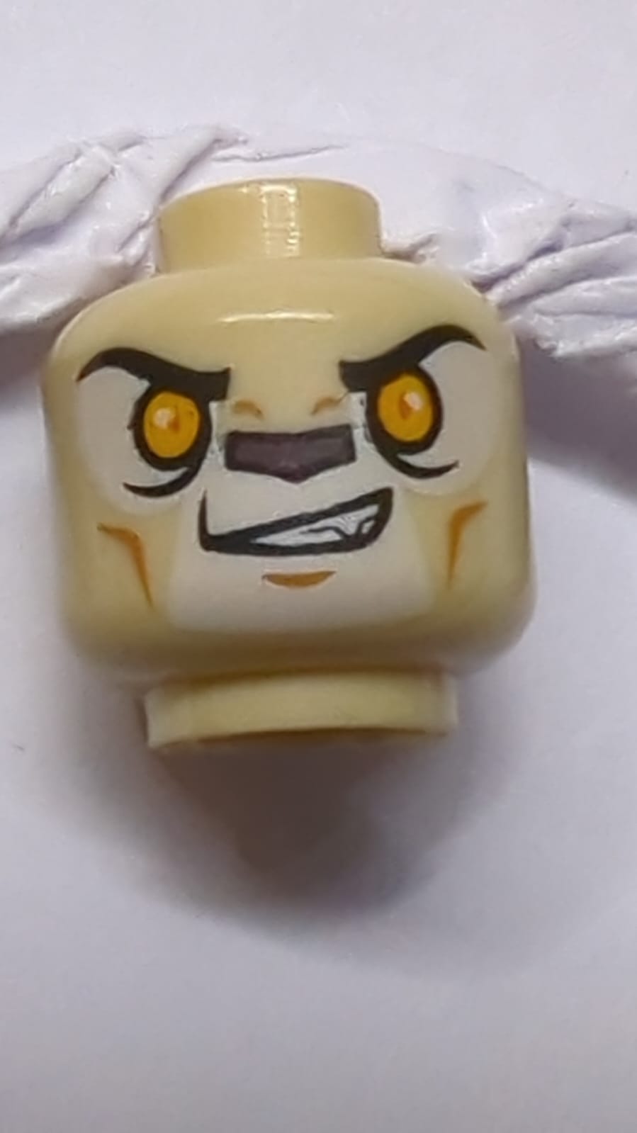 Kopf eines doppelseitigen Alien Chima Löwen mit leuchtend orangefarbenen Augen und dunkler brauner Nase, geschlossenes Mund- / offenes Mundmuster (Laval) beige