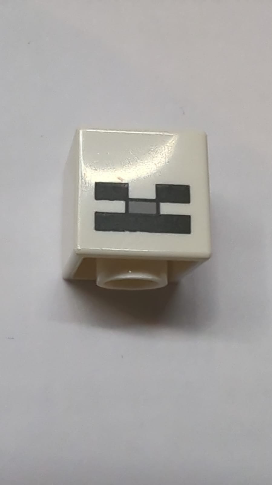 Kopf, Modifizierter Würfel mit pixeligen schwarzen Augen, hellblaugrauer Nase und schwarzem Mundmuster (Minecraft-Skelett) weiß