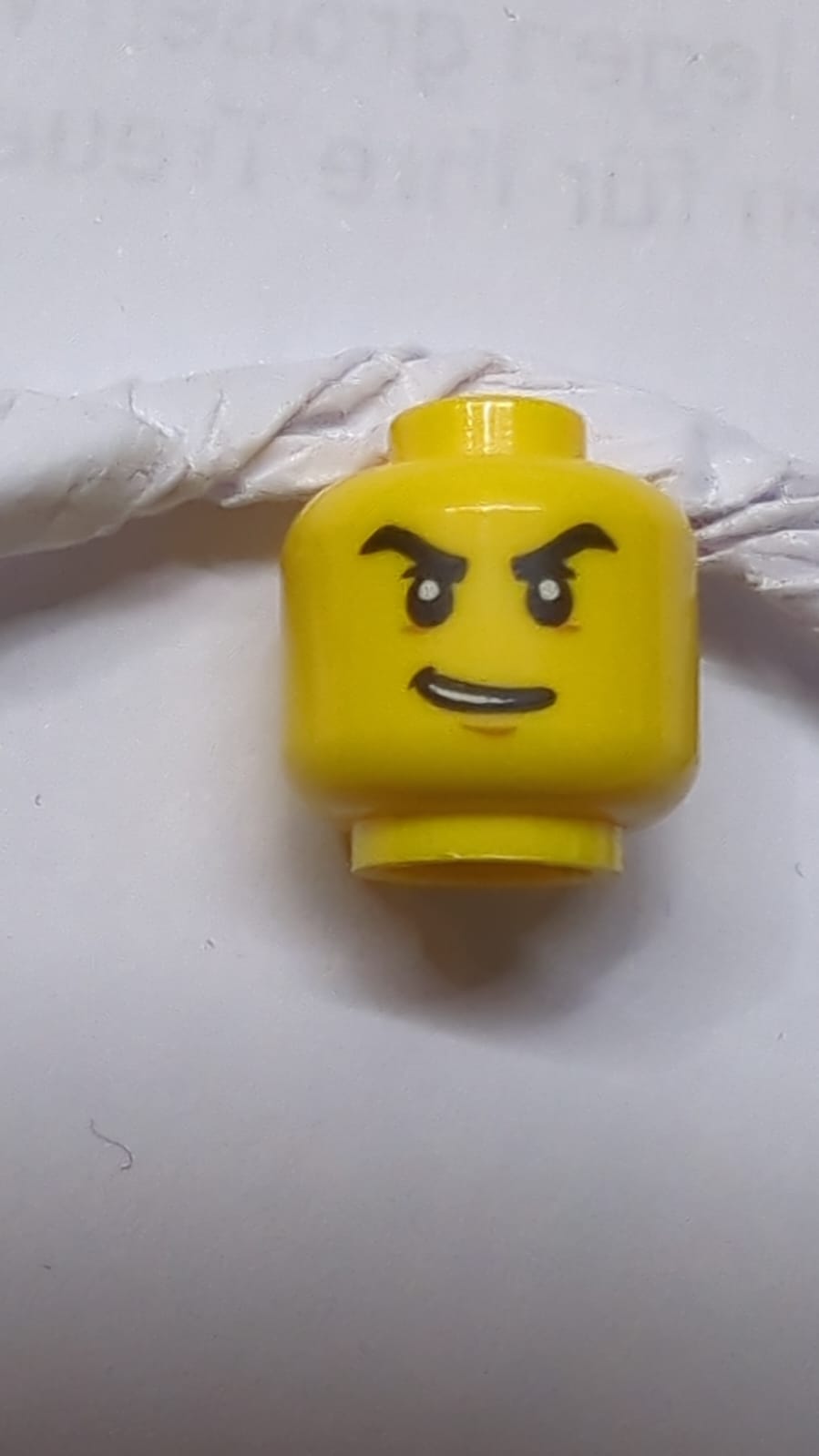 Kopf mit schwarzen, dicken, wütenden Augenbrauen, schiefem offenem Lächeln-Muster gelb