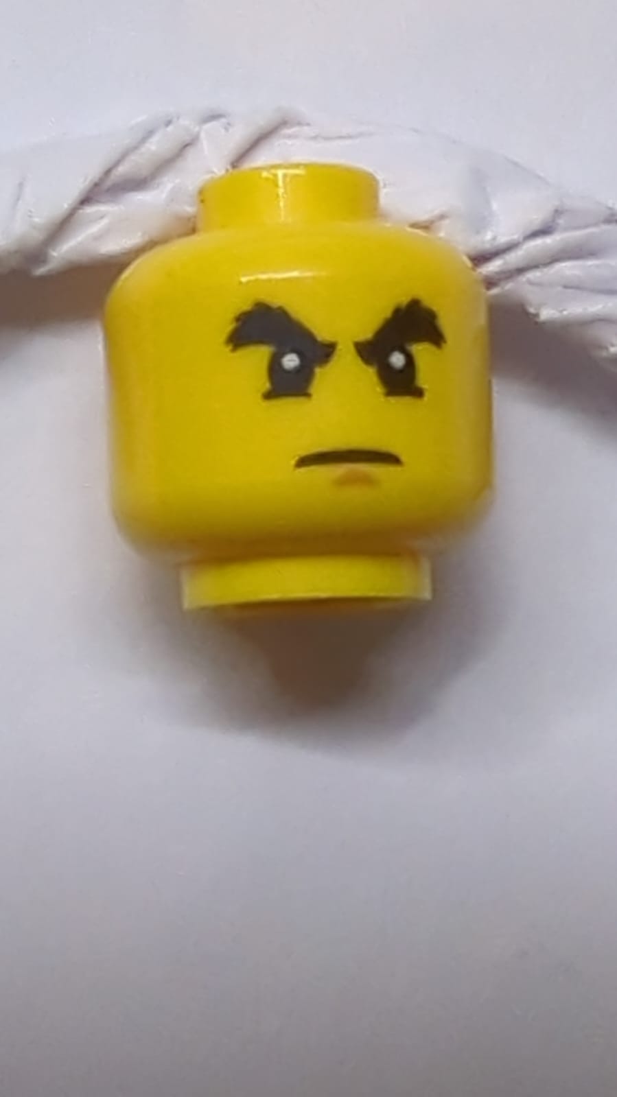 Kopf Schwarze buschige Augenbrauen, Unterlider, mittlere Nougat-Kinngrübchen, strenger Ausdruck gelb