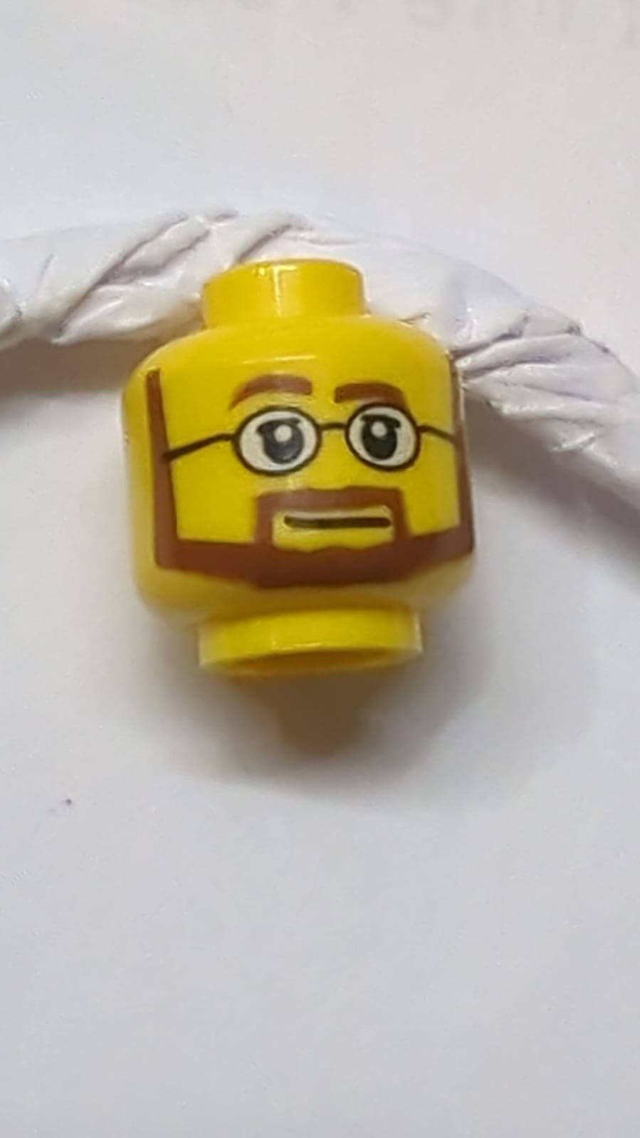 Kopf rötlich-braune Augenbrauen, Schnurrbart und kantiger Bart, obere Augenlider, schwarze Brille mit weißen Gläsern, neutrales Muster gelb