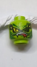 Kopf eines Außerirdischen mit gelben Schlangenaugen, Narben über dem linken Auge, dunkelgrünen Markierungen, weitem schief geöffnetem Mund mit Fängen und rotem Zungenmuster lindgrün