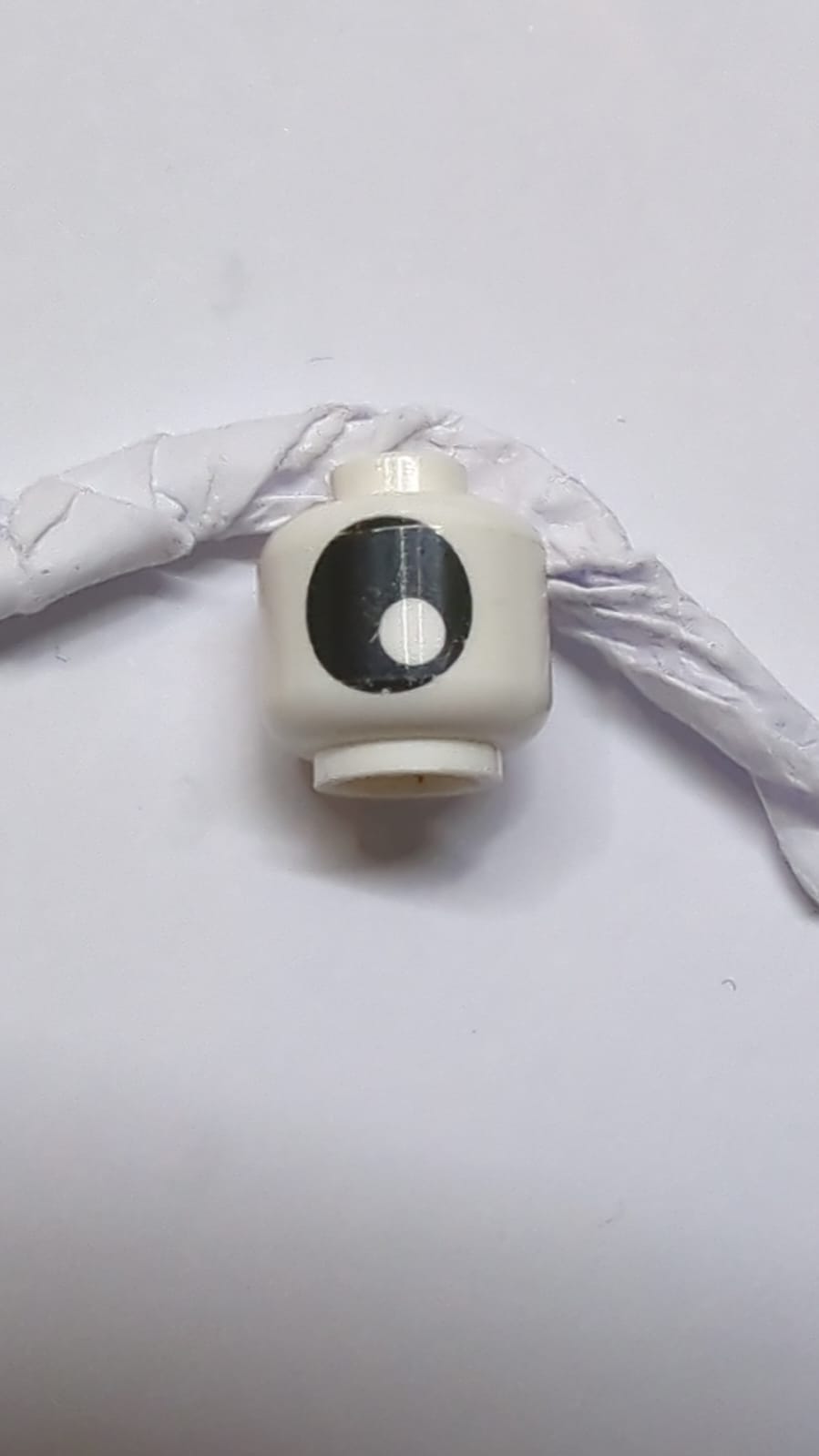 Kopf ohne Gesicht mit großem schwarzem Auge mit Pupillenmuster weiß