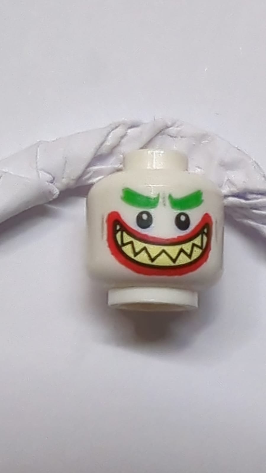 Kopf mit doppelseitigen buschigen grünen Augenbrauen, dicken roten Lippen, hellgelben scharfen Zähnen, weit geöffnetem Mundlächeln, Zähne zusammen / Zähne auseinander Muster (Der Joker) weiß