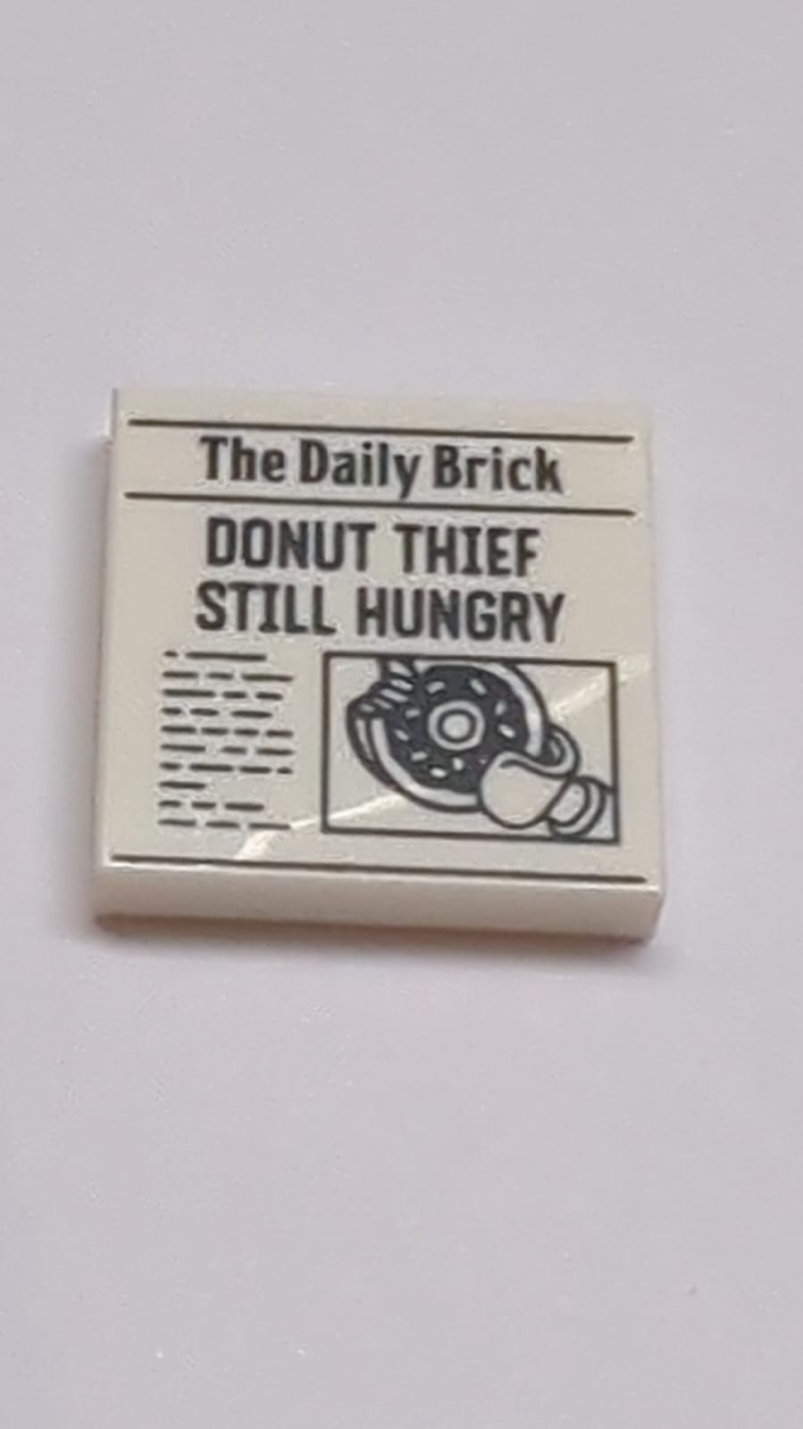 NEU Fliese 2 x 2 mit Rille mit Zeitung 'The Daily Brick' und Muster 'DONUT THIEF STILL HUNGRY' weiß