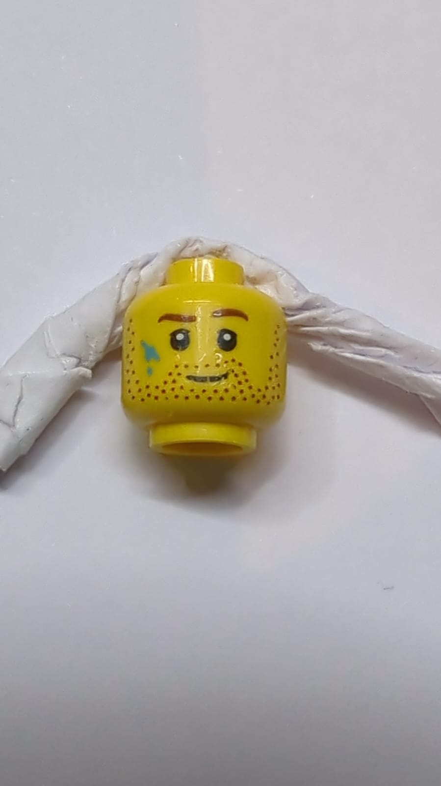 Kopf mit Bartstoppeln, braune Augenbrauen und Farbfleckenmuster gelb