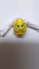 Kopf mit schwarzen Augenbrauen und Grübchen am Kinn, hellblau-graue Gesichtsstreifen, strenges Muster gelb