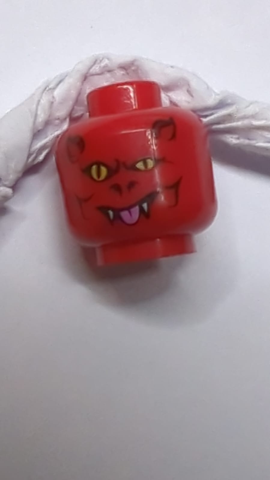 Alien-Teufelskopf mit Hörnern, gelben Augen, weißen Reißzähnen und hellrosa Zungenmuster rot