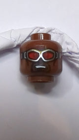 Kopf beidseitig bedruckt, Brille mit silbernen Schutzbrillen und roten Gläsern, schwarzer Kinnbart, Lächeln / geöffneter Mund mit finsterem Ausdruck neubraun