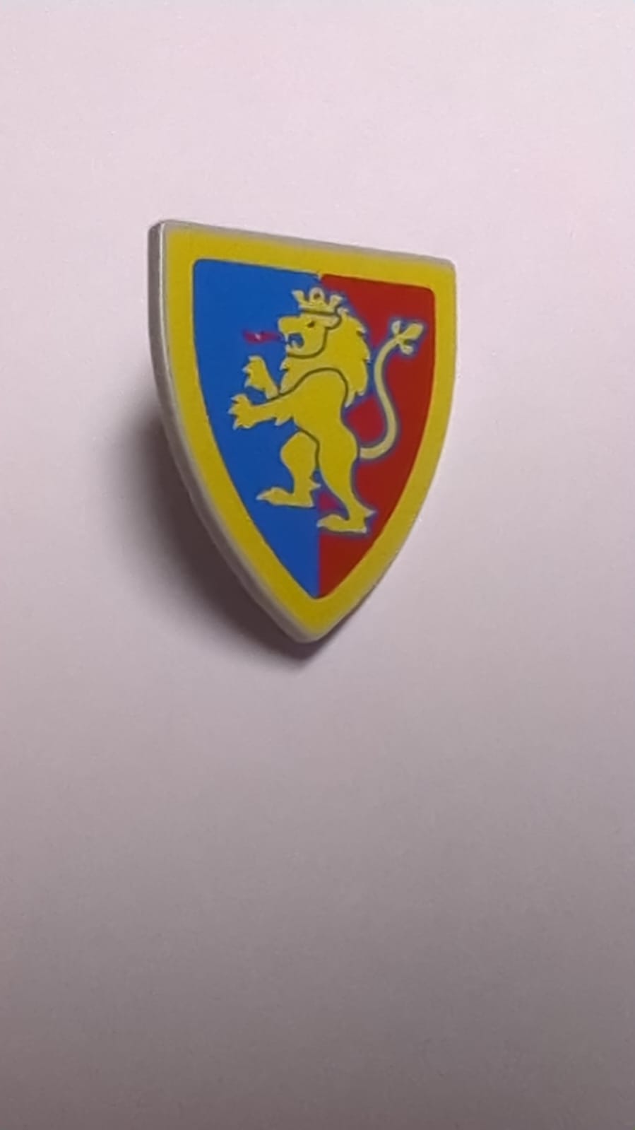 NEU Dreieckiger Schild mit gelbem Löwen mit erhobenem Fuß auf blauem und rotem Hintergrund mit Randmuster neuhellgrau