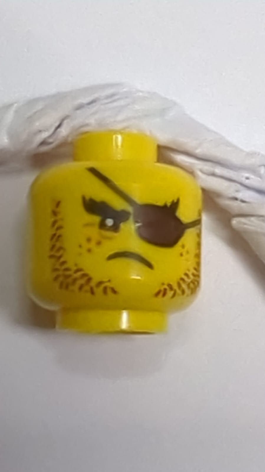 Minifigur, Kopf mit braunem Stoppelbart, dunkelbraunem Augenklappe, Sommersprossenmuster gelb