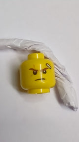 Minifigur, Kopf beidseitig Rötlich-braune Augenbrauen, mittlerer Nougatnarben, Verband, schiefer Grinsen mit Zähnen / Entschlossenes Muster (Kai) gelb