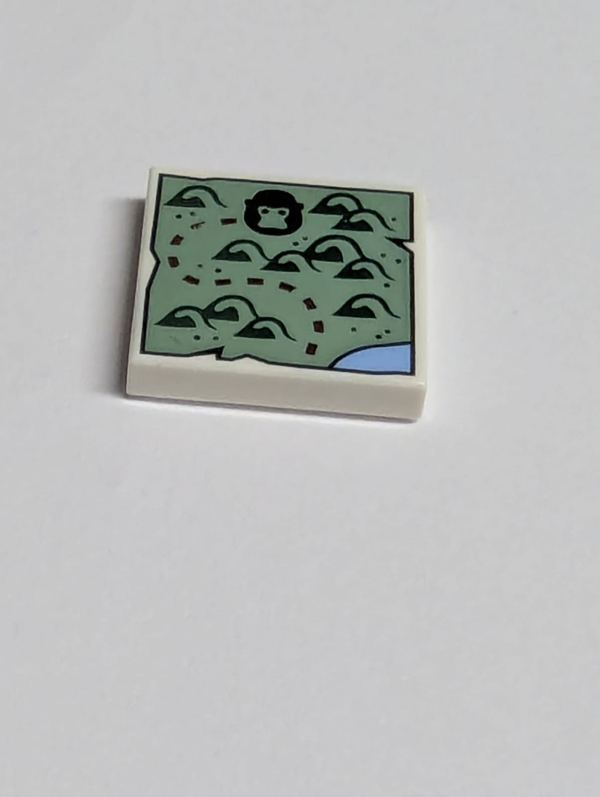 NEU Fliese 2 x 2 mit Karte mit sandgrüner Landschaft, dunkelgrünen Bäumen, schwarzem Tigerkopf und dunkelrotem gepunktetem Linienmuster weiß