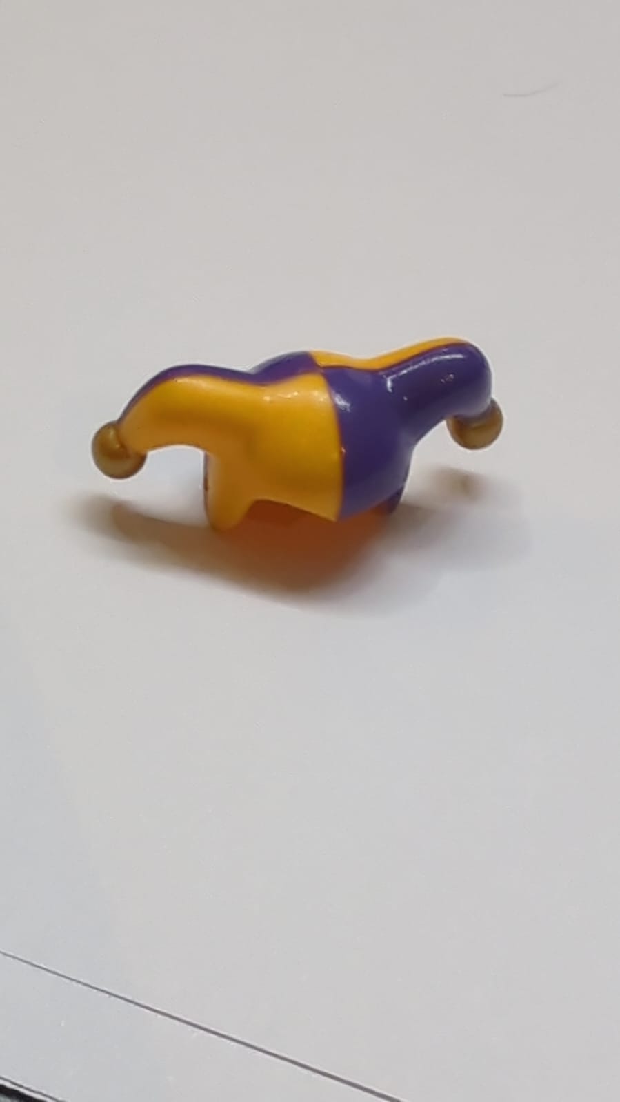Minifigur, Kopfbedeckung: Narrenkappe mit dunkelvioletter linker Seite und goldenem Bommelmuster hellorange