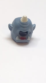 Minifigur, Kopfbedeckung: Zyklopenmaske mit weißem Horn, weißen Zähnen, magentafarbenem Lippenstift und schwarzem Schönheitsfleckmuster sandblau