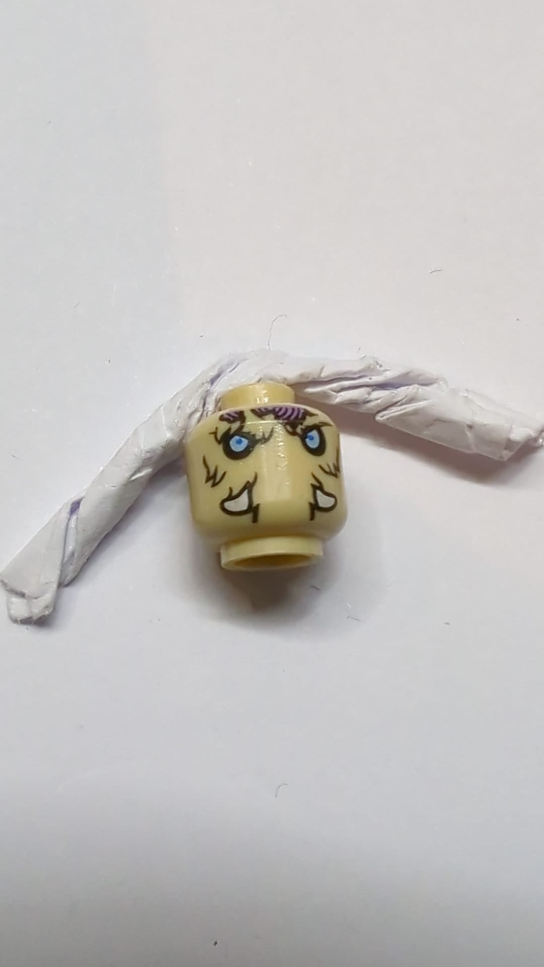 Minifigur, Kopf doppelseitig, Alien Chima Mammut, hellblaue Augen, mittelviolette Flecken, Stoßzähne, neutrales/strenges Muster „Mottrot“ beige