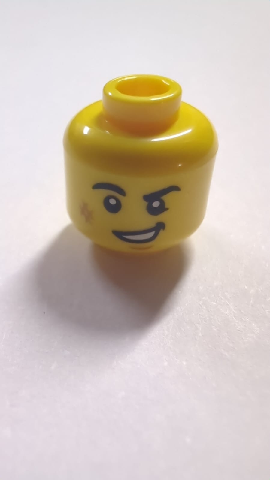 NEU Minifigur, Kopf mit schwarzen Augenbrauen, rechtwinklig, mittleres Nougat-Schrammenzeichen und Kinngrübchen, schiefes offenes Mundlächeln mit Zahnstruktur gelb