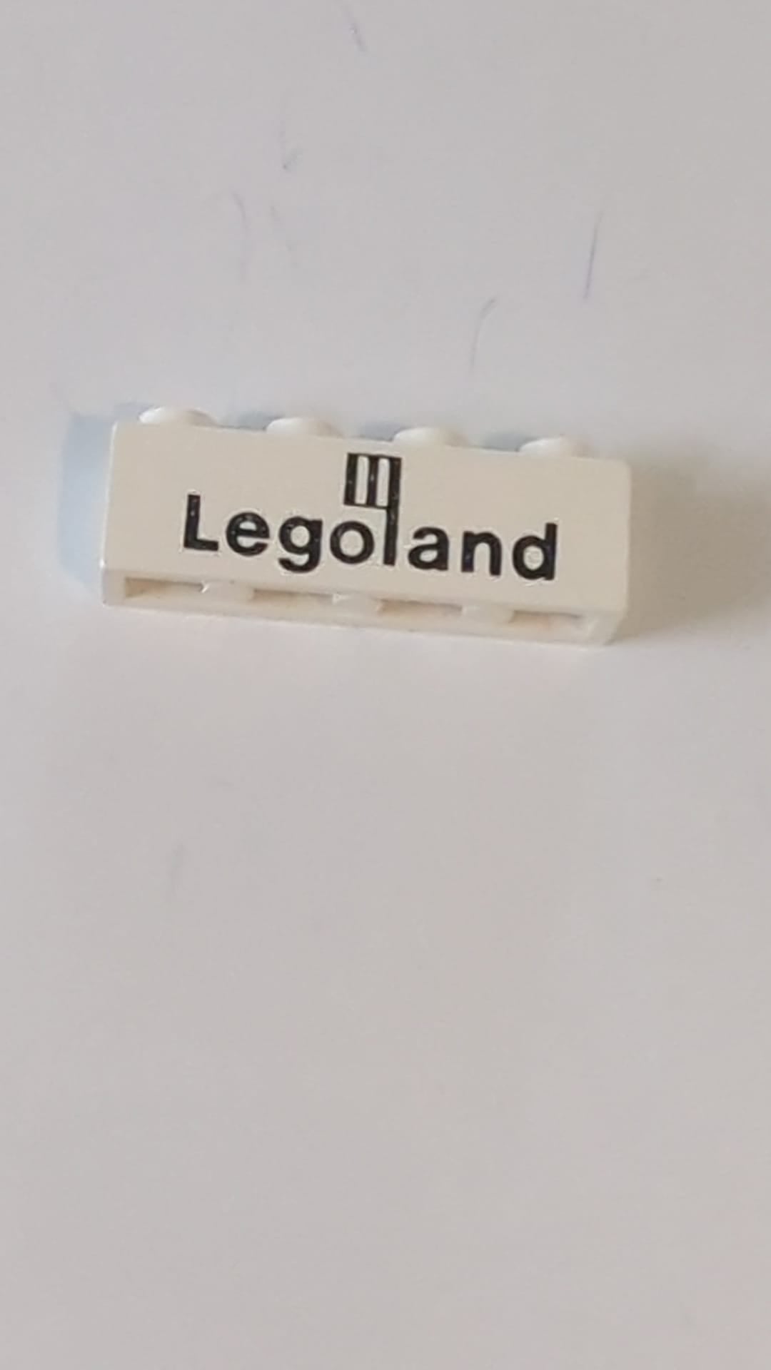 1x4 Stein mit schwarzem Legoland-Logo-Muster weiß