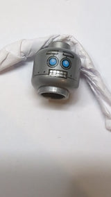 Minifigur, Alienkopf mit roboterhaften blauen Augen, hochgezogenen Augenbrauen, offenem Mund und zusammengebissenen silbernen Zähnen dunkles Pearlsilber