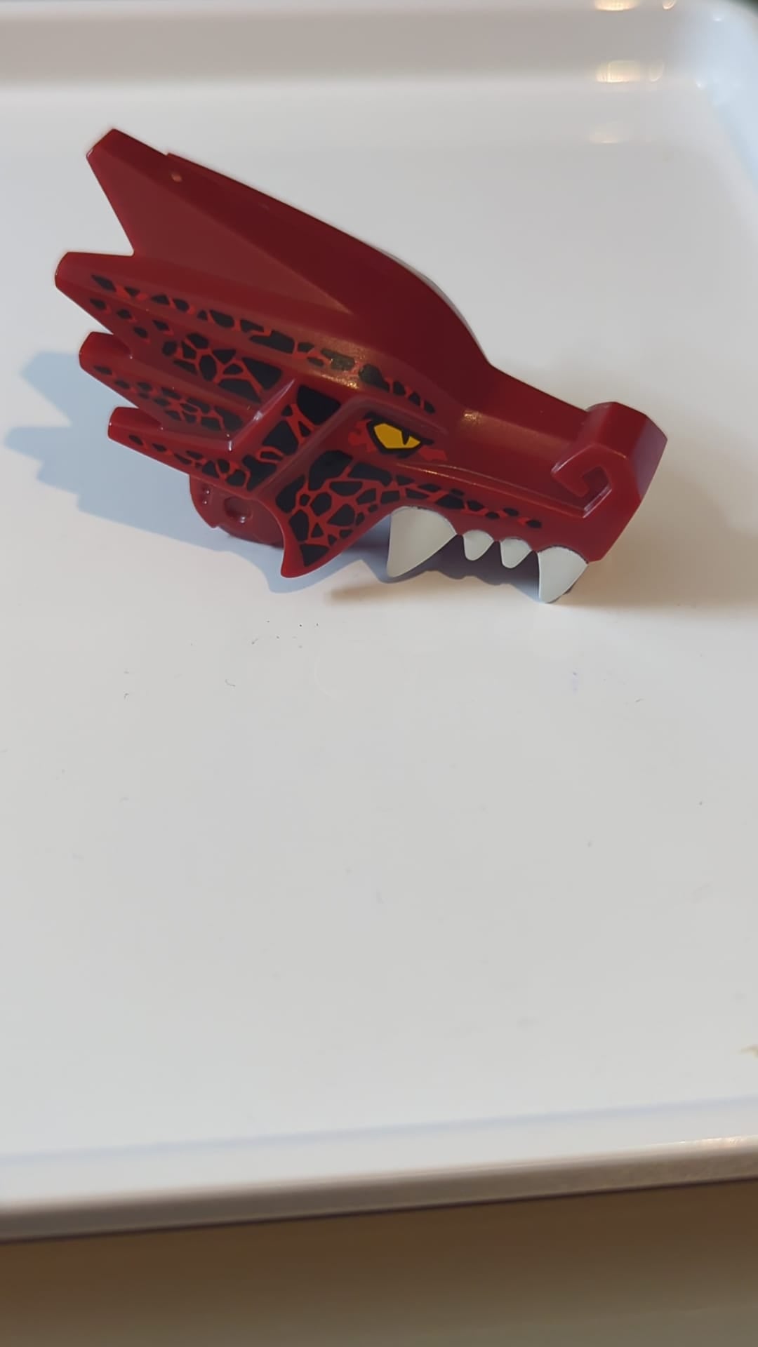 Drachenkopf „Ninjago“ Oberkiefer mit vier weißen Zähnen pro Seite, gelben Augen und schwarz-rotem Zeichnungsmuster dunkelrot