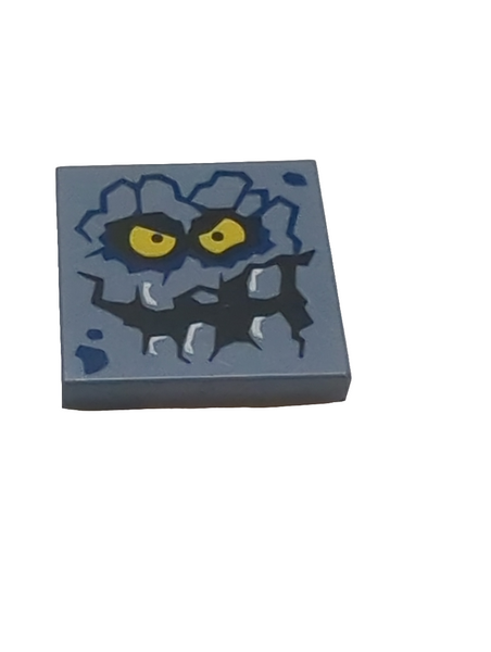 2x2 Fliese bedruckt with Rock Creature Face with Jagged Grin, Dark Blue Spots and Yellow Eyes Pattern (Brickster) sandblau sand blue