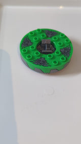 6x6x1 1/3 Ninjago Spinner runde Basis mit Zahnkranz, Oberseite in Hellgrün und Muster aus dunkelbläulich-grauen Steinköpfen pearlsilber