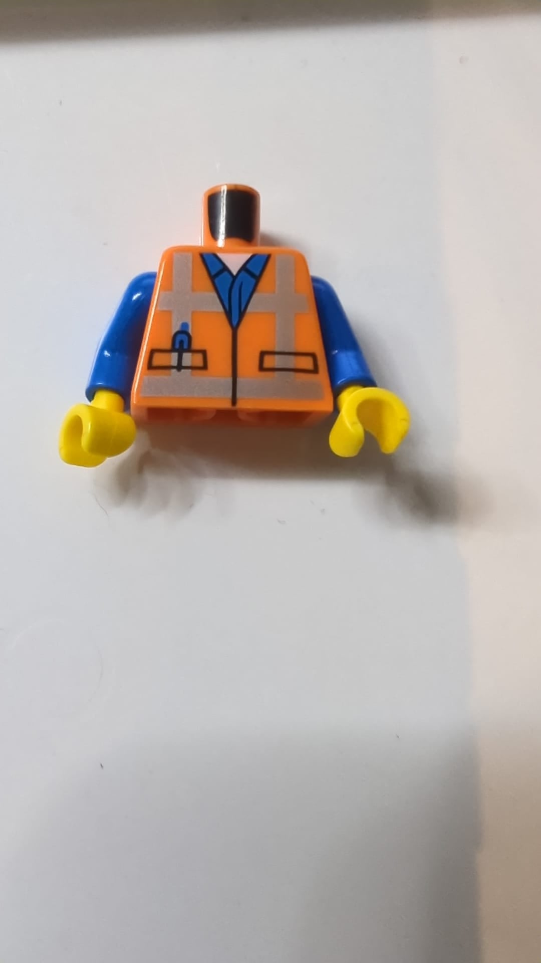 Sicherheitsweste für den Oberkörper mit reflektierenden, gekreuzten Streifen über blauem Hemdmuster / blaue Arme / gelbe Hände orange