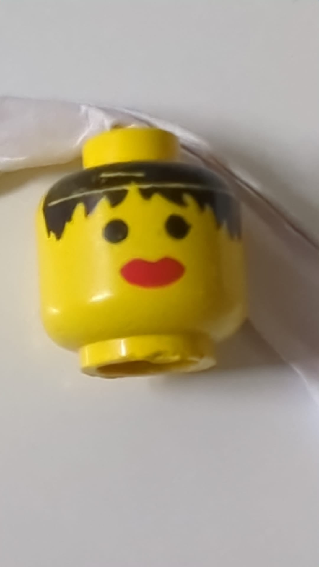 Minifigur, weiblicher Kopf, schwarzes, zerzaustes Haar, dicke rote Lippen (Muster) gelb