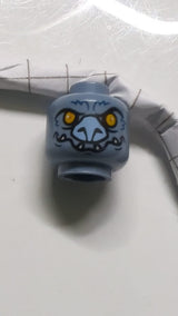 Minifigur, Kopf einer außerirdischen Chima-Fledermaus mit leuchtend orangefarbenen Augen, lavendelfarbener Nase, dunkelblauen Fellstreifen und weißem Fangmuster sandblau