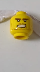 Minifigur, Kopf: rötlich-braun, buschige Augenbrauen und Bartstoppeln, offener Mund, finsterer Blick mit sichtbaren Zähnen gelb