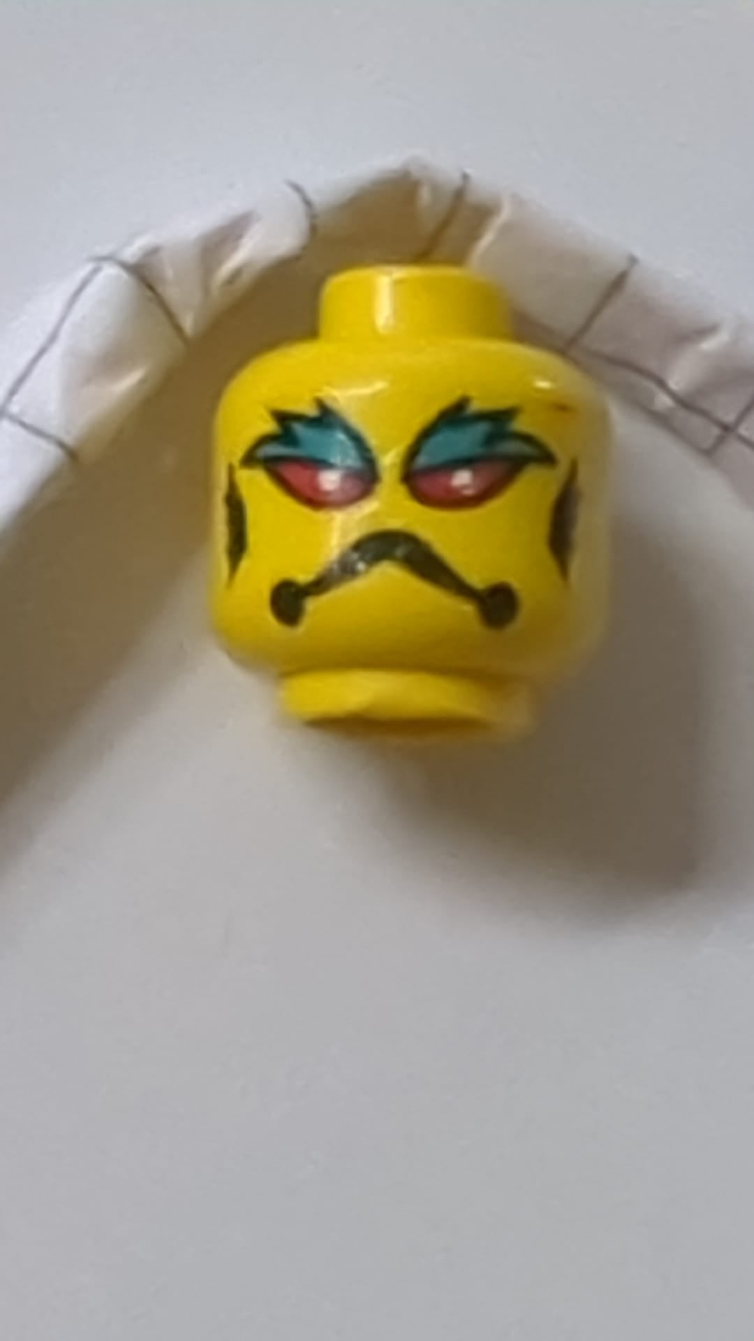 Minifigur, Alienkopf mit roten Augen, weißen Pupillen, dunkeltürkisfarbenen Augenbrauen, schwarzem Stirnrunzeln und Kiemenmuster gelb