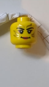Minifigur, weiblicher Kopf, schwarze Augenbrauen, goldene Streifen im Gesicht, korallenfarbene Lippen und Lidschatten, Lächelnmuster „BAM“ gelb