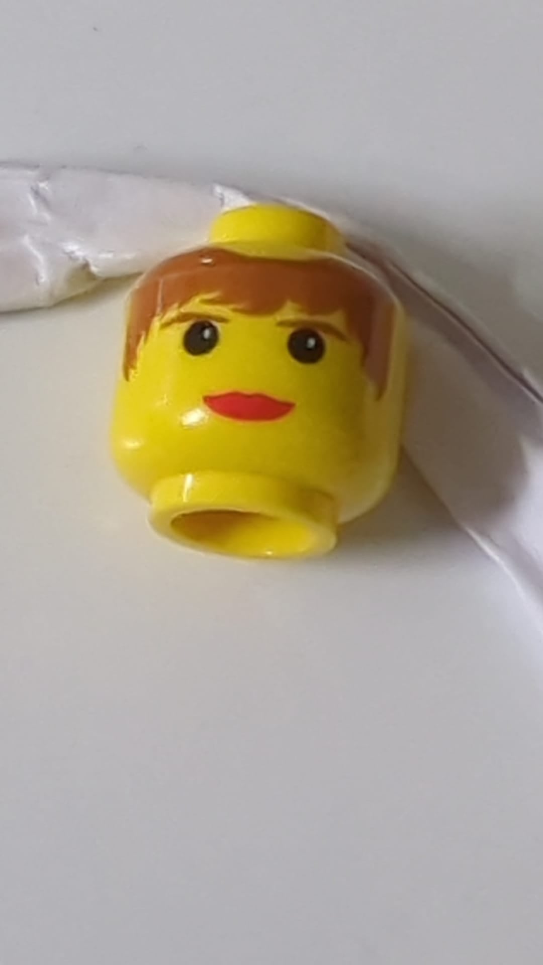 Minifigur, weiblicher Kopf mit roten Lippen, braunem Haar und Augenbrauenmuster gelb