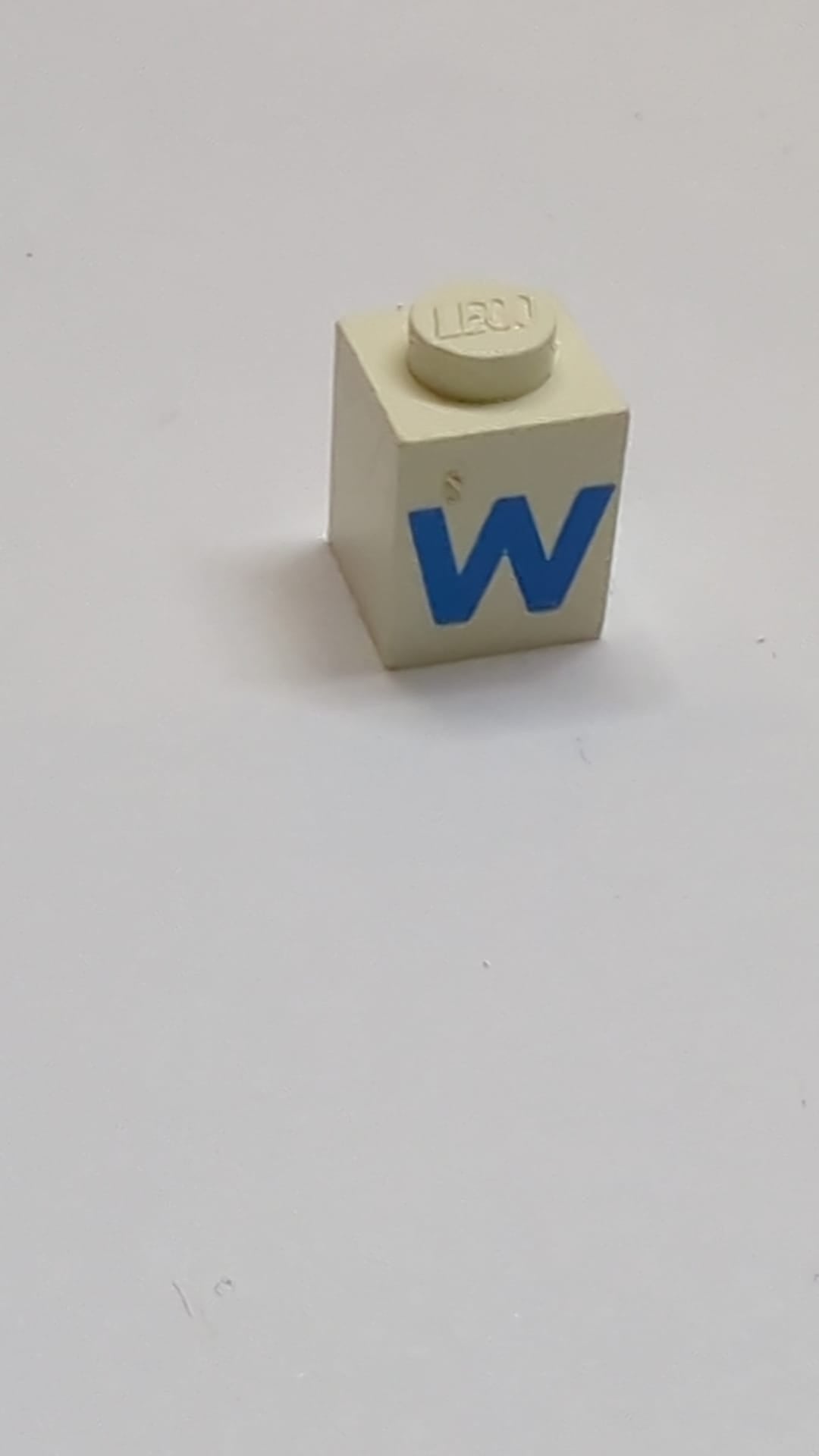1x1 Stein mit blauem Großbuchstaben-W-Muster Fettschrift weiß