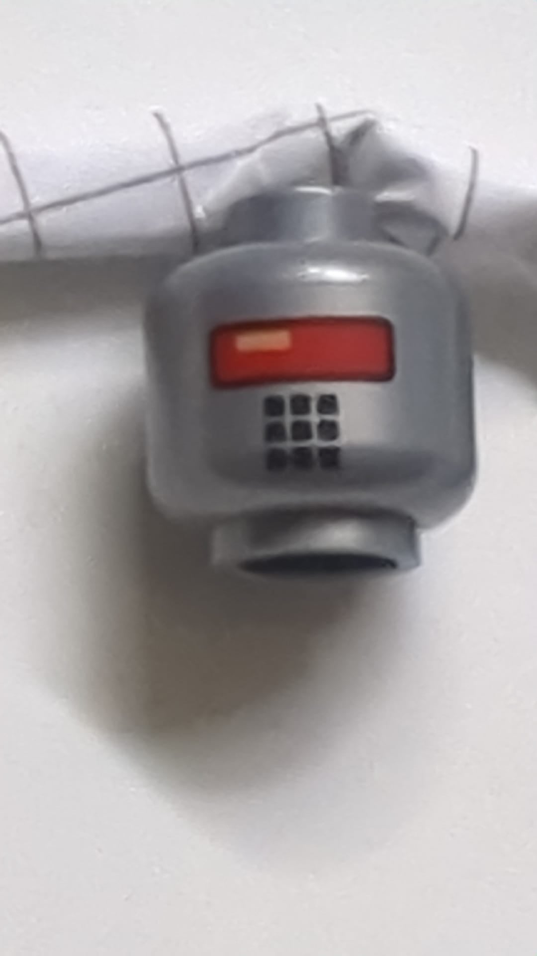 Minifigur, Kopf eines Alien-Roboters mit rotem Visier und 9 Mundquadraten dunkles Pearlsilber