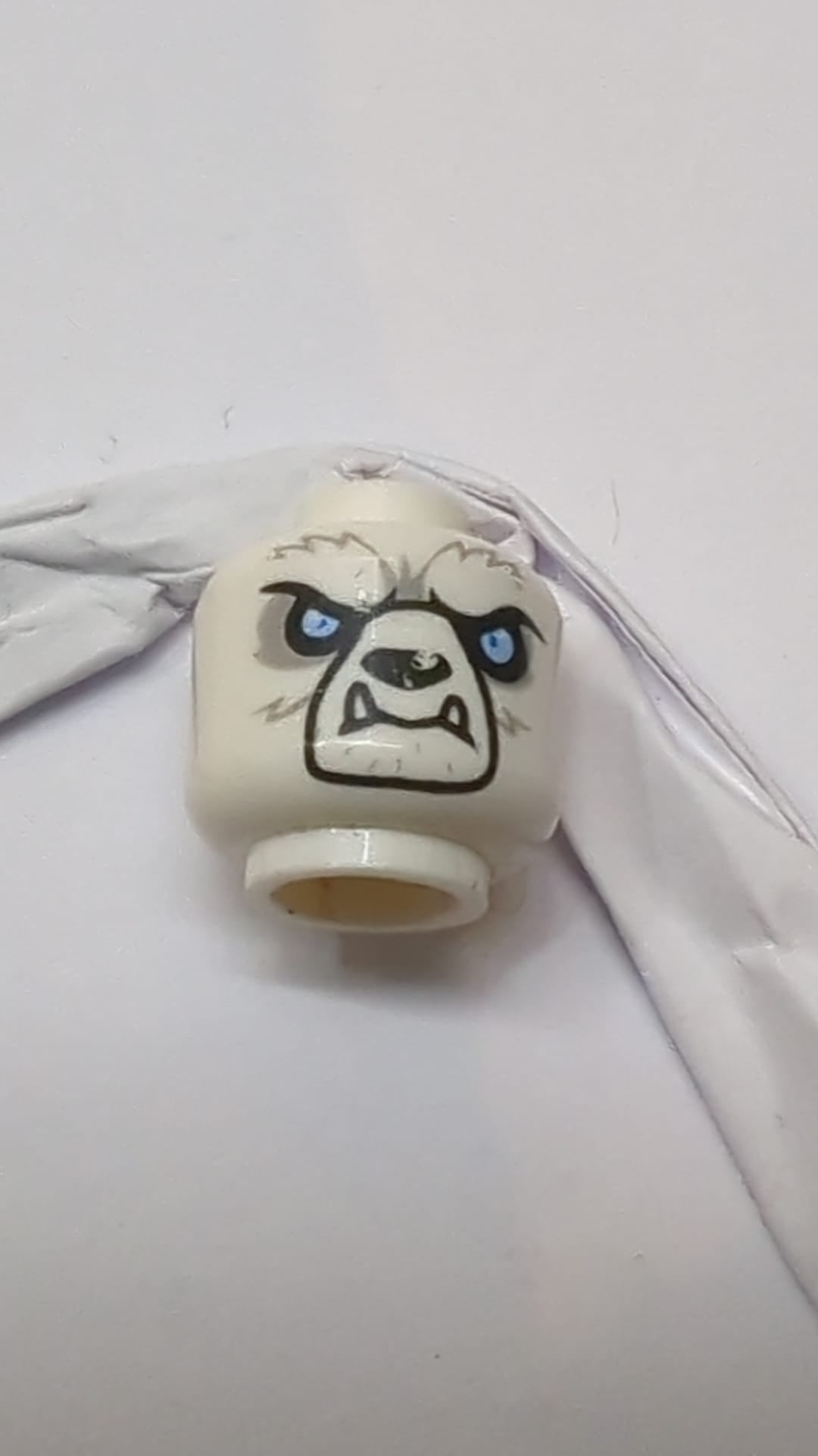 Minifigur, außerirdischer Chima-Bär-Kopf mit schwarzer Nase, hellblauen Augen, hellblaugrauem Fell, unteren Eckzähnen und sandblauem Stammesmuster weiß