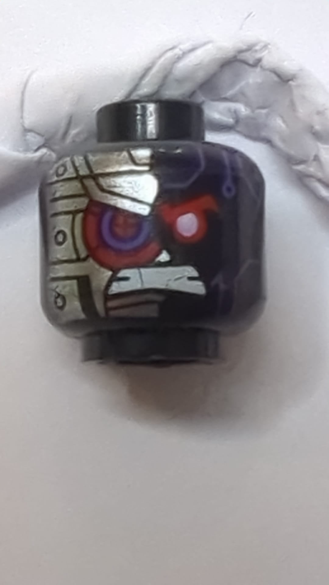 NEU Minifigur, Kopf: Alien, dunkelviolette Akzente, rotes Auge, zusammengebissene Zähne, silbernes Panzermuster auf der rechten Seite schwarz