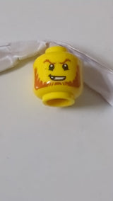 Minifigur, Kopf, dunkelorangefarbene Augenbrauen und Bart, abgebrochener Zahn, entschlossenes Grinsen, Pupillenmuster gelb