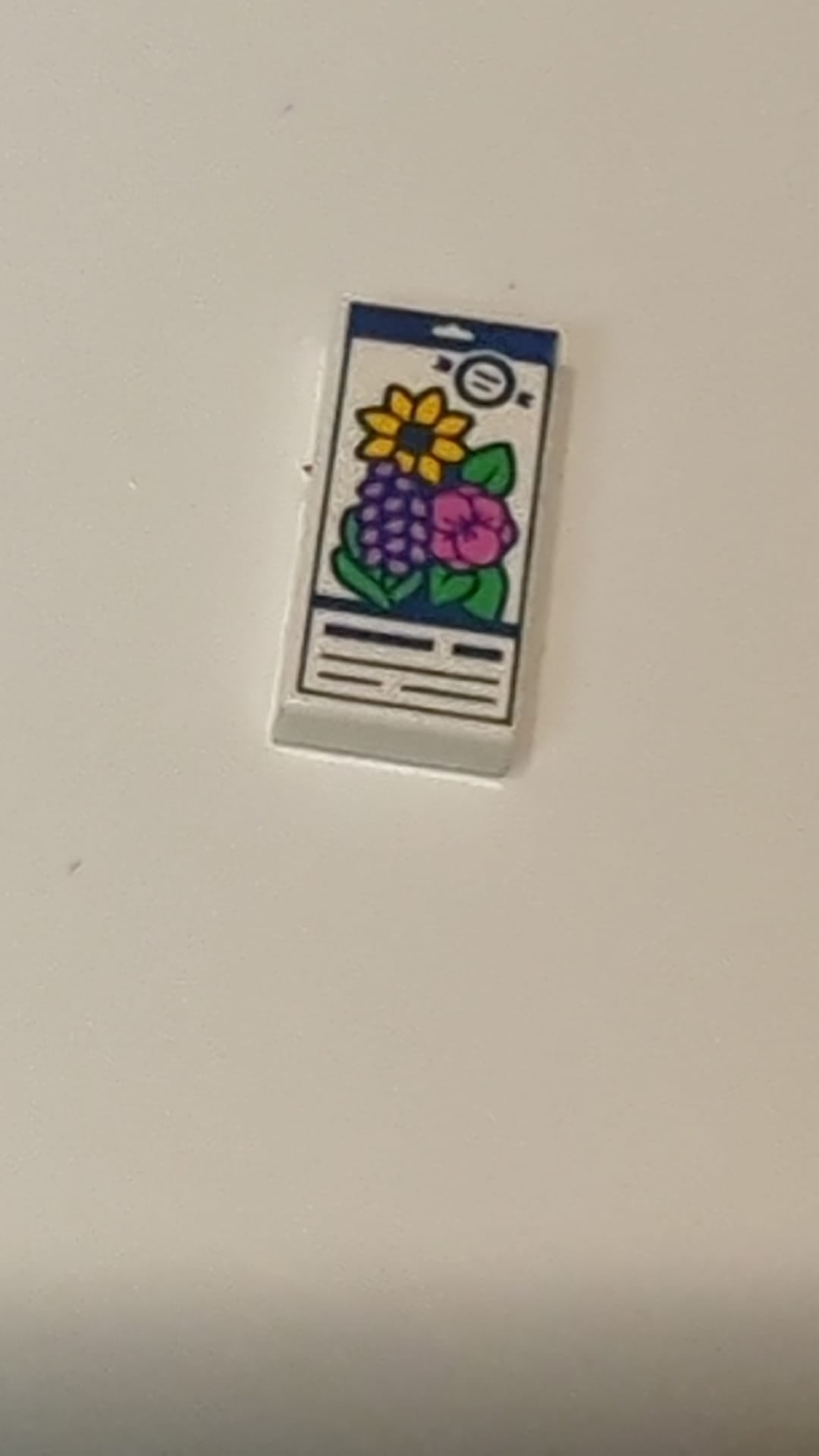 NEU 1 x 2 Fliese mit Samenpäckchen-Motiv (dunkelblaue Linien; Blumen in hellem Hellorange, Dunkelrosa und mittlerem Lavendel; hellgrüne Blätter) weiß